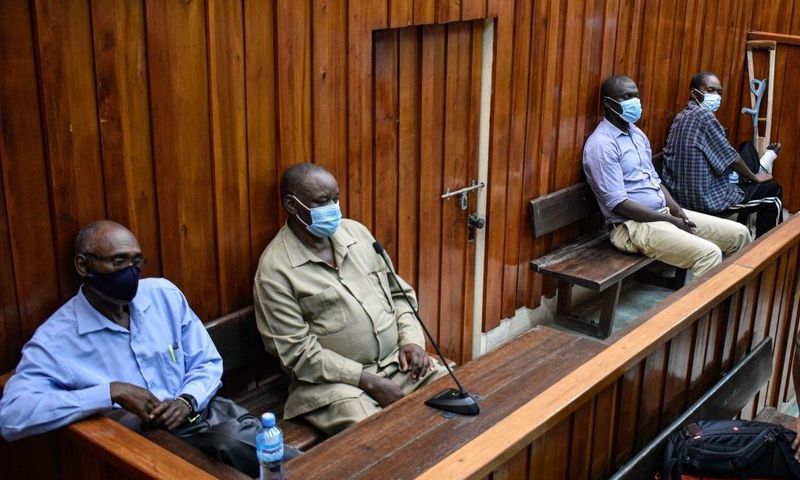 Kenyan police officers, Naftali Chege (L), Charles Munyiri Wagombe (2nd-L), Ismael Baraka Bulima (2nd-R) and John Pamba (R), sit in the dock at the Mombasa Law Court in Mombasa, on November 15, 2021. (Photo by DIHOFF MUKOTO/AFP via Getty Images)