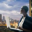 Businesswoman holding her laptop by the Nairobi city skyline