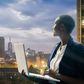 Businesswoman holding her laptop by the Nairobi city skyline