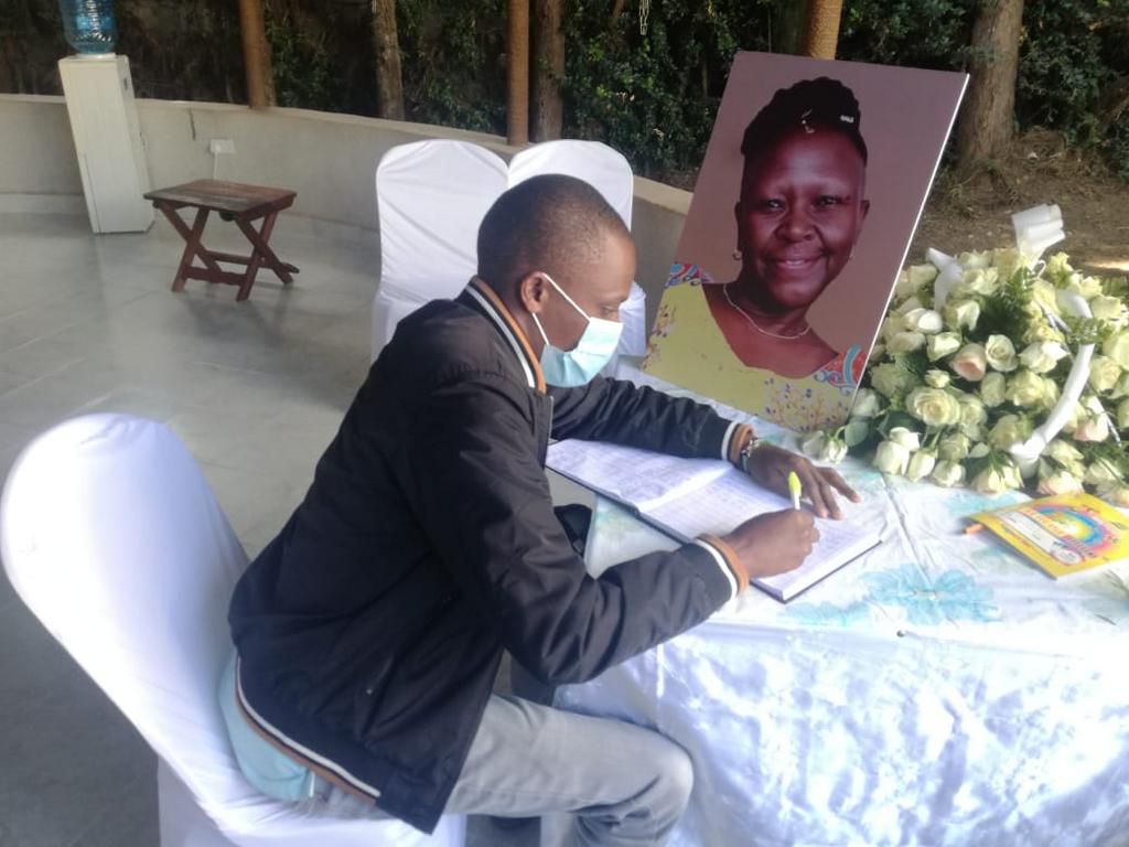 A mourner signs the condolence book for the late Jennifer Wambua
