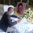 A mourner signs the condolence book for the late Jennifer Wambua