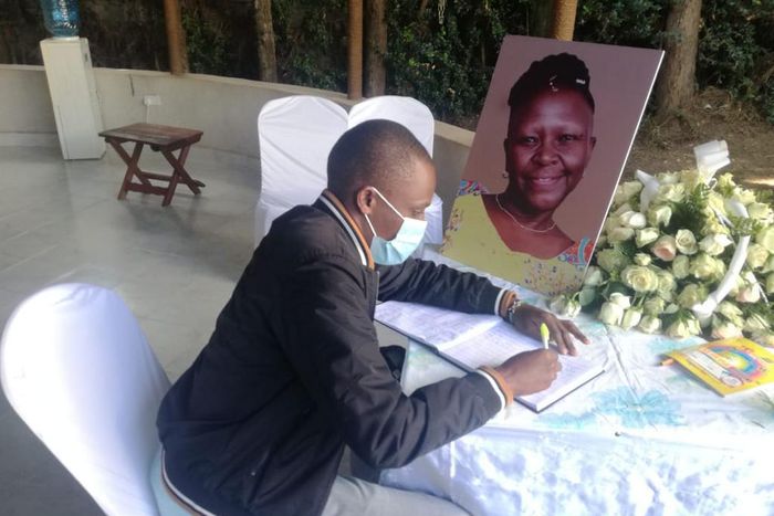 A mourner signs the condolence book for the late Jennifer Wambua