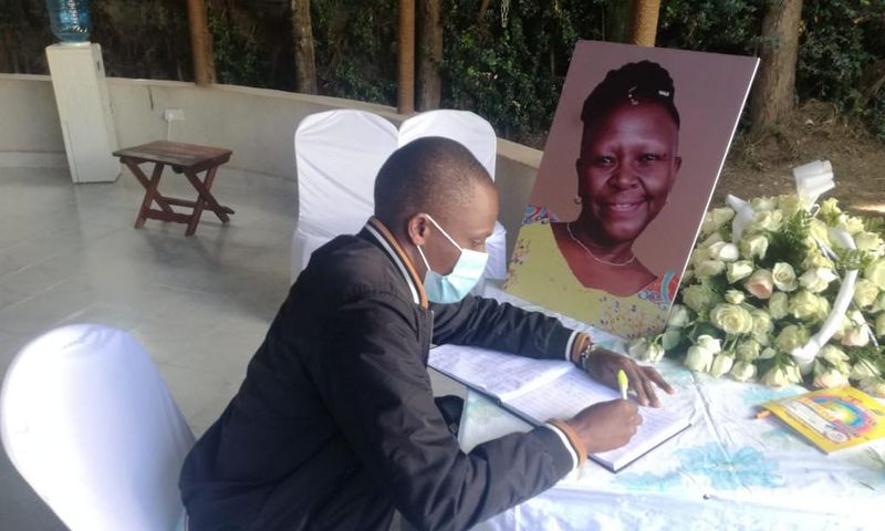 A mourner signs the condolence book for the late Jennifer Wambua