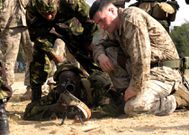A US Marine Soldier helps a member of the KDF assume the proper position for sniper shooting.
