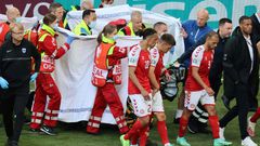 Players escort paramedics as Denmark's midfielder Christian Eriksen is evacuated from the pitch during the UEFA EURO 2020 Group B football match between Denmark and Finland at the Parken Stadium in Copenhagen on June 12, 2021.