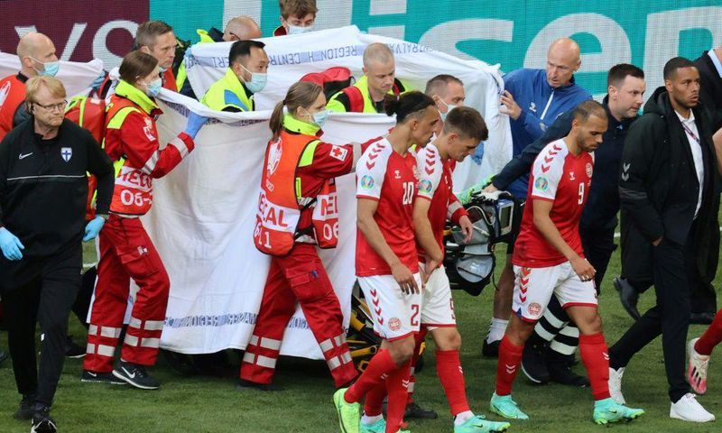 Players escort paramedics as Denmark's midfielder Christian Eriksen is evacuated from the pitch during the UEFA EURO 2020 Group B football match between Denmark and Finland at the Parken Stadium in Copenhagen on June 12, 2021.