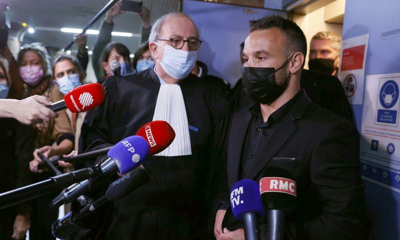 French football player Mathieu Valbuena (R), involved in a 'sex tape case', addresses media representatives next to lawyer Paul Albert Iweins (C) inside a court
