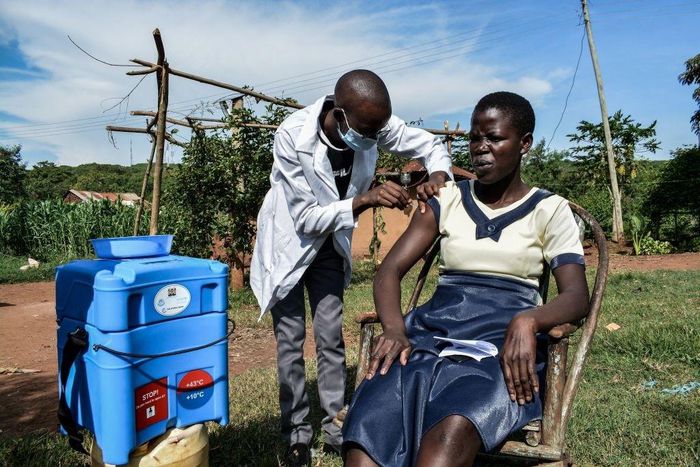 TOPSHOT - A medical health worker injects the Oxford/AstraZeneca Covid-19 vaccine to a woman as they visit door-to-door to deliver the vaccines to people who live far from health facilities in Siaya, Kenya, on May 18, 2021. (Photo by Brian ONGORO / AFP...