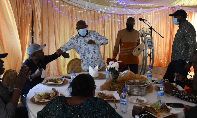Guests eating at Kieni MP Kanini Kega's home during an event to celebrate his son's rite of passage