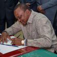 President Uhuru Kenyatta signing a document in his office