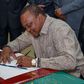 President Uhuru Kenyatta signing a document in his office