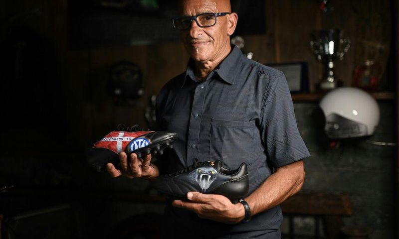 Italian artist Salvatore Cosentino poses with a pair of boots he designed as a tribute to Christian Eriksen