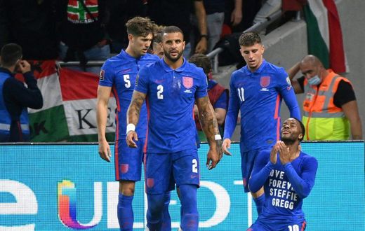 England's forward Raheem Sterling (R) celebrates his opening goal, with a cup thrown by Hungary fans in the background