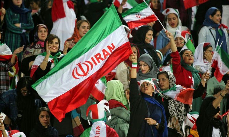 Iranian women cheer ahead of the World Cup Qatar 2022 Group C qualification football match between Iran and Cambodia at the Azadi stadium in the capital Tehran on October 10, 2019