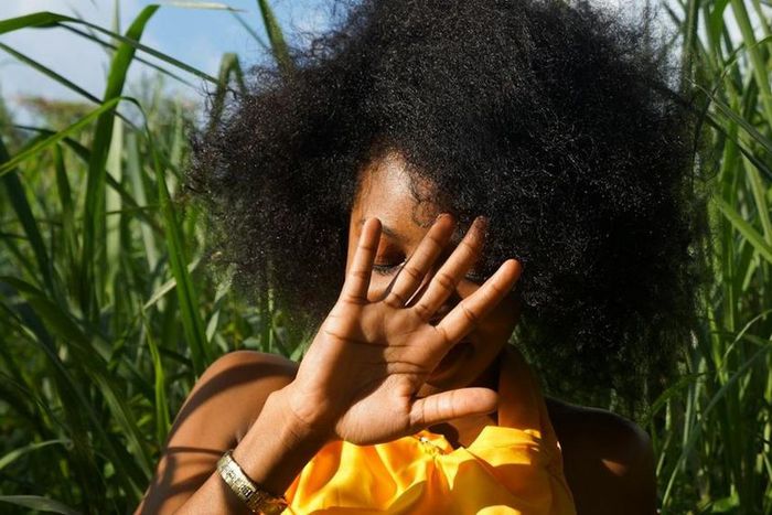 Photo of woman hiding her face using her right hand [Image: Ricaldo Donaldson]