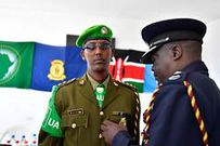Bernard Nyakwaka pins a medal on a Kenyan police officer who completed his tour of duty under the African Union Mission in Somalia (AMISOM)