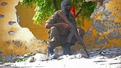 A Somali soldier stands guard next to the site where Al Shebab militants carried out a suicide attack against a military intelligence base in Mogadishu on June 21, 2015. Shebab militants launched a major suicide raid on June 21 against a military intel...