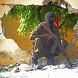 A Somali soldier stands guard next to the site where Al Shebab militants carried out a suicide attack against a military intelligence base in Mogadishu on June 21, 2015. Shebab militants launched a major suicide raid on June 21 against a military intel...