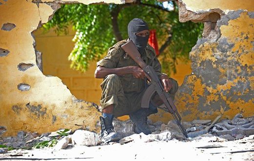 A Somali soldier stands guard next to the site where Al Shebab militants carried out a suicide attack against a military intelligence base in Mogadishu on June 21, 2015. Shebab militants launched a major suicide raid on June 21 against a military intel...