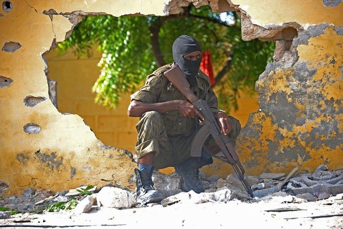 A Somali soldier stands guard next to the site where Al Shebab militants carried out a suicide attack against a military intelligence base in Mogadishu on June 21, 2015. Shebab militants launched a major suicide raid on June 21 against a military intel...