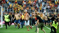 Lens supporters invade the pitch at half-time of the northern derby against Lille