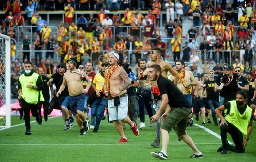 Lens supporters invade the pitch at half-time of the northern derby against Lille