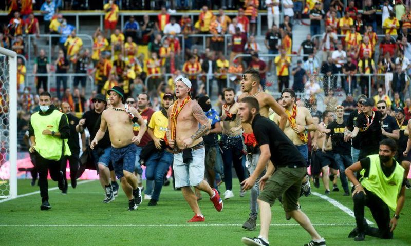 Lens supporters invade the pitch at half-time of the northern derby against Lille