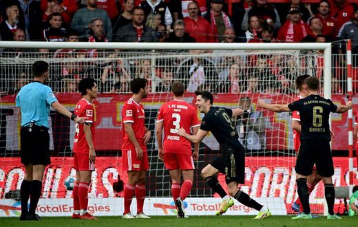 Bayern Munich striker Robert Lewandowski (C) celebrates after scoring from a free-kick at Union Berlin on Saturday