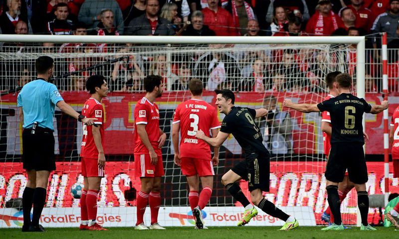 Bayern Munich striker Robert Lewandowski (C) celebrates after scoring from a free-kick at Union Berlin on Saturday