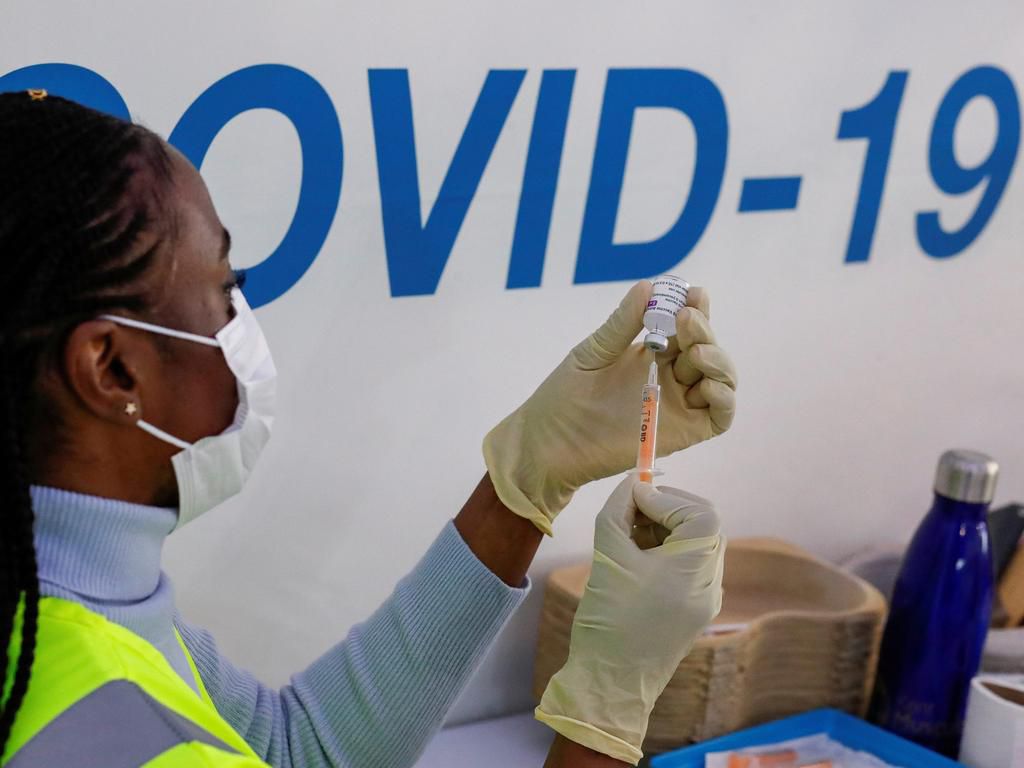 A woman prepares to administer a COVID-19 vaccine.