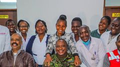 President Uhuru Kenyatta (in camouflage jacket) poses for a photo with health staff in one of the facilities
