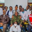 President Uhuru Kenyatta (in camouflage jacket) poses for a photo with health staff in one of the facilities