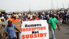 People hold a banner as they protest against hiked in pump price by the government during a worker's rally at Gani Fawehinmi Partk, Ojota district in Lagos on January 13, 2012. The government and Labour are scheduled to meet again tomorrow to resolve the stalement at yesterday's meeting in order to put an end to on-going strike following government scrapping of fuel subsidy. AFP PHOTO/ PIUS UTOMI EKPEI (Photo credit should read PIUS UTOMI EKPEI/AFP via Getty Images)