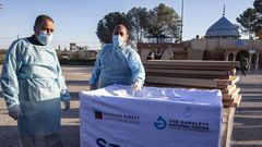 Health workers next to boxes of Sputnik V vaccine doses from the UAE upon the arrival of a truckload in the Gaza Strip on February 21.