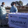 Health workers next to boxes of Sputnik V vaccine doses from the UAE upon the arrival of a truckload in the Gaza Strip on February 21.