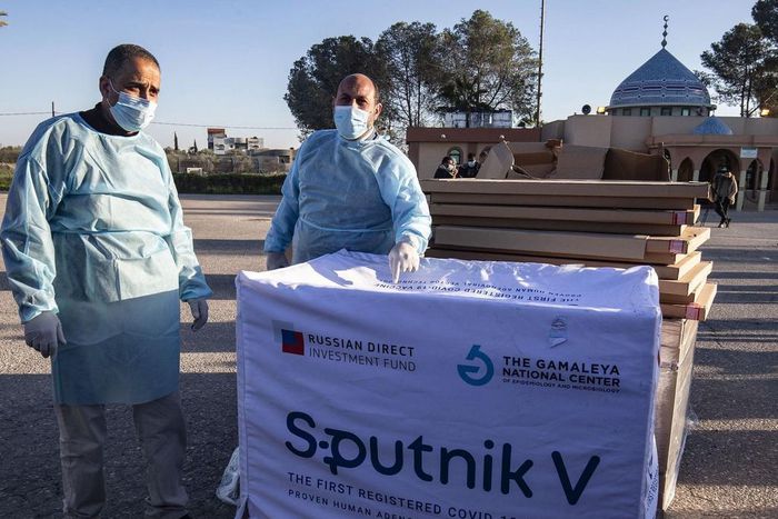 Health workers next to boxes of Sputnik V vaccine doses from the UAE upon the arrival of a truckload in the Gaza Strip on February 21.