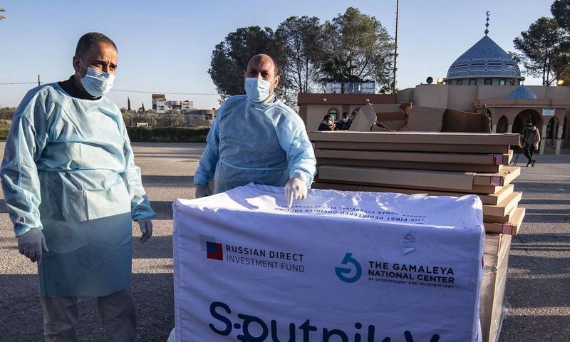 Health workers next to boxes of Sputnik V vaccine doses from the UAE upon the arrival of a truckload in the Gaza Strip on February 21.