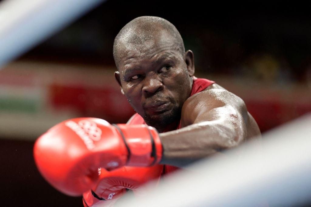 Kenya's Elly Ajowi Ochola (red) and Cuba's Julio La Cruz shake fight during their men's heavy (81-91kg) preliminaries round of 16 boxing match during the Tokyo 2020 Olympic Games at the Kokugikan Arena in Tokyo on July 27, 2021. (Photo by UESLEI MARCELINO / POOL / AFP) (Photo by UESLEI MARCELINO/POOL/AFP via Getty Images)