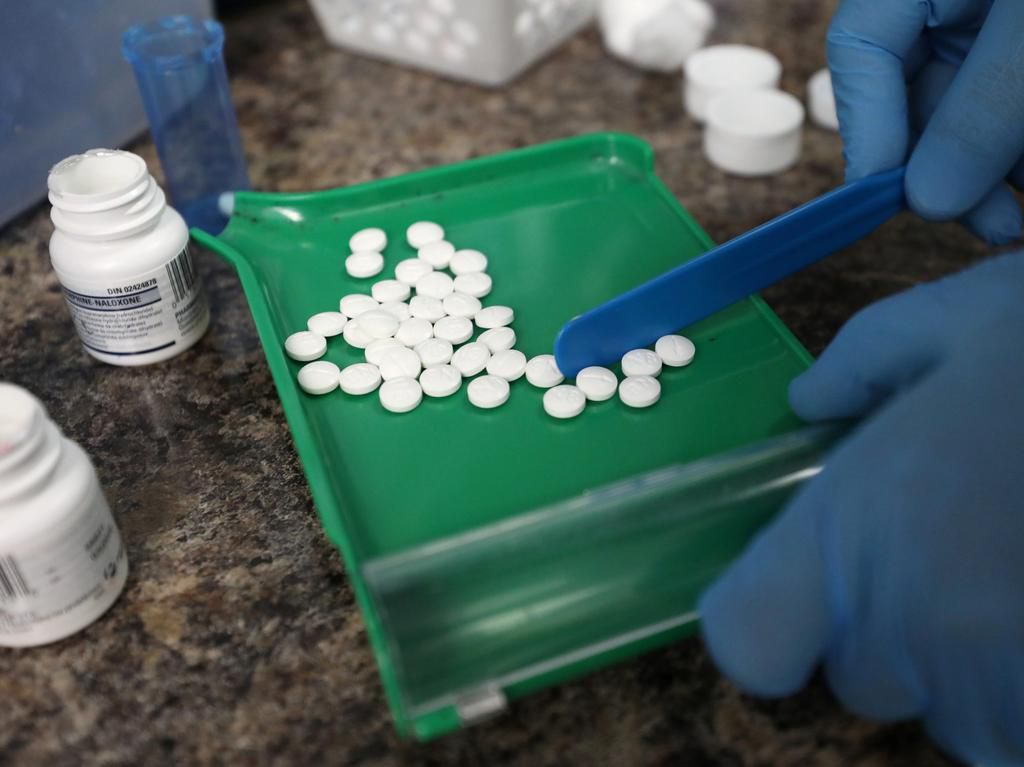 A pharmacist is seen counting prescription pills in June, 2019.