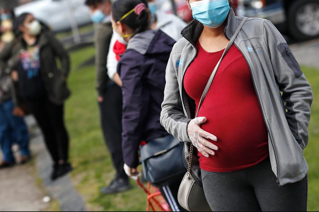 A pregnant woman wears a mask during the beginning of the COVID-19 pandemic.