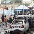 Civilians and Somalian security officers gather at the scene of a suicide car bomb at a street junction near the president's residence, in Mogadishu, Somalia, September 25, 2021. REUTERS/Feisal Omar