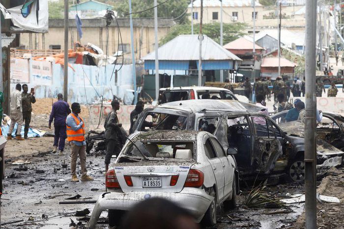 Civilians and Somalian security officers gather at the scene of a suicide car bomb at a street junction near the president's residence, in Mogadishu, Somalia, September 25, 2021. REUTERS/Feisal Omar