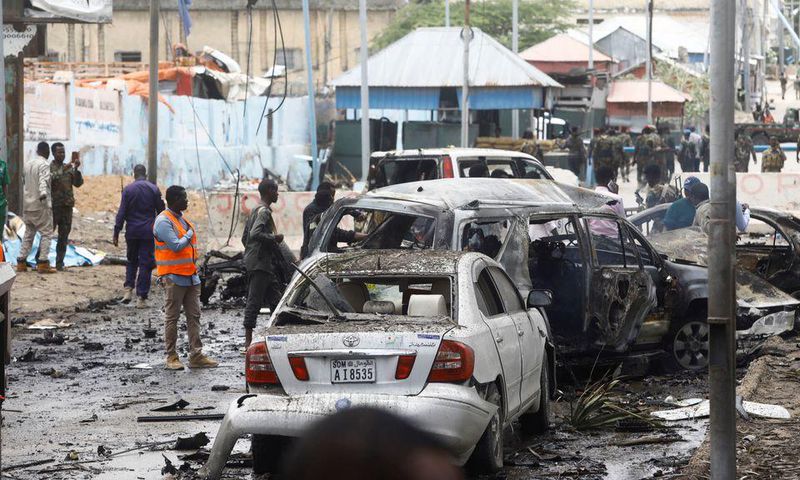 Civilians and Somalian security officers gather at the scene of a suicide car bomb at a street junction near the president's residence, in Mogadishu, Somalia, September 25, 2021. REUTERS/Feisal Omar