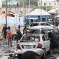Civilians and Somalian security officers gather at the scene of a suicide car bomb at a street junction near the president's residence, in Mogadishu, Somalia, September 25, 2021. REUTERS/Feisal Omar