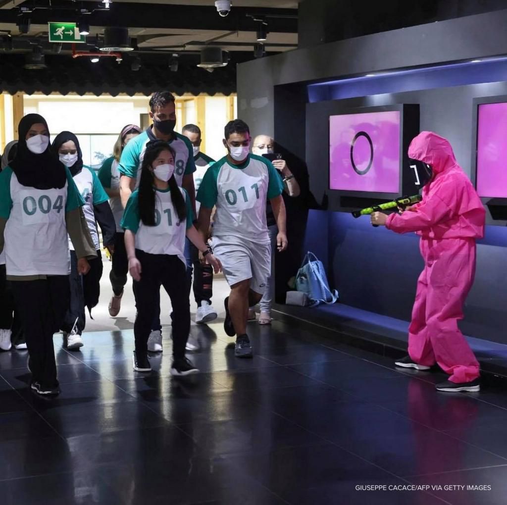 Two teams of 15, wearing T-shirts featuring the show's logo, played red light green light, Dalgona candy challenge, and paper-flipping games Marbles and Ddakji.
