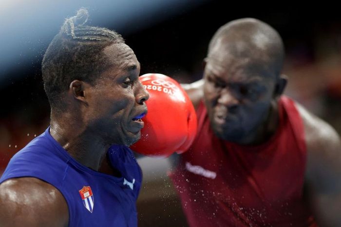 TOKYO, JAPAN - JULY 27: Elly Ajowi Ochola (red) of Kenya exchanges punches with Julio la Cruz of Cuba during the Men's Heavy (81-91kg) on day four of the Tokyo 2020 Olympic Games at Kokugikan Arena on July 27, 2021 in Tokyo, Japan. (Photo by Ueslei Mar...