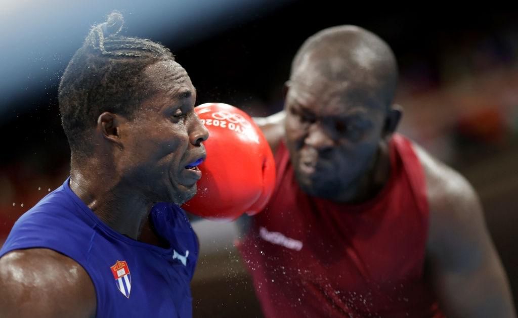TOKYO, JAPAN - JULY 27: Elly Ajowi Ochola (red) of Kenya exchanges punches with Julio la Cruz of Cuba during the Men's Heavy (81-91kg) on day four of the Tokyo 2020 Olympic Games at Kokugikan Arena on July 27, 2021 in Tokyo, Japan. (Photo by Ueslei Marcelino - Pool/Getty Images)