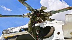 Chief Inspector Justine Ouya at work, atop an Mi-17 Police troop carrier.