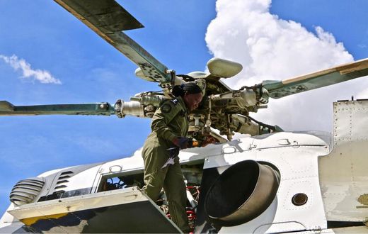 Chief Inspector Justine Ouya at work, atop an Mi-17 Police troop carrier.