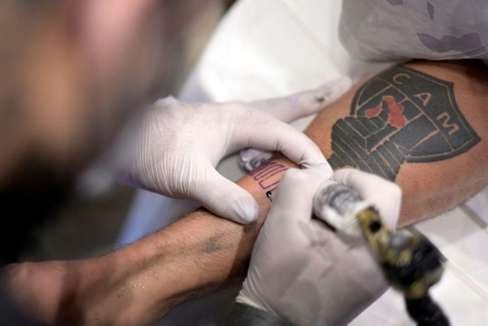 A fan of Brazilian team Atletico Mineiro gets a free tattoo offered by the company constructing the new stadium after the squad won the Brazilian Championship